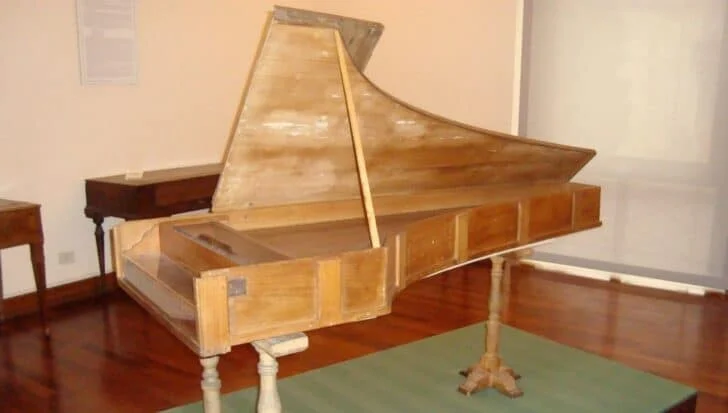 An original Cristofori piano displayed in a museum setting, showcasing the historical design of one of the three remaining pianos created by Bartolomeo Cristofori