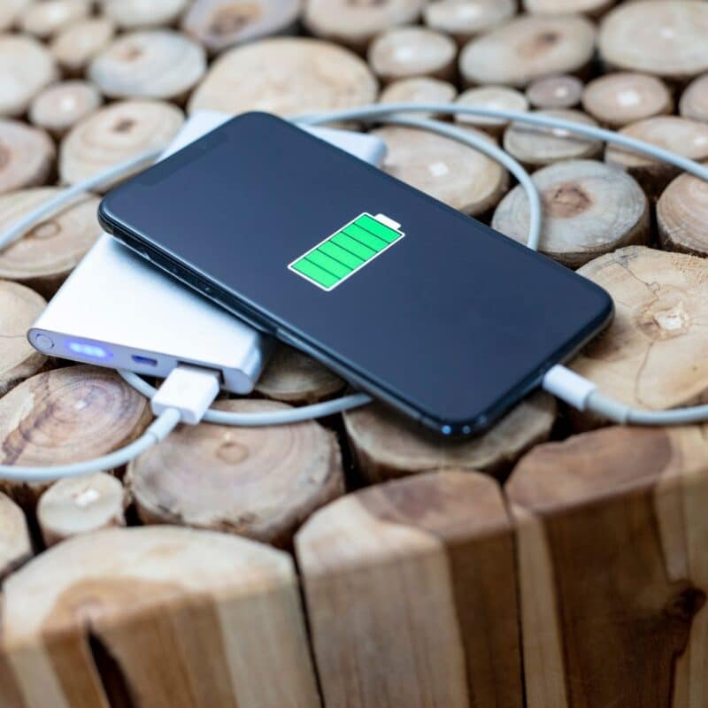 Smartphone charging on a portable power bank with a full battery indicator