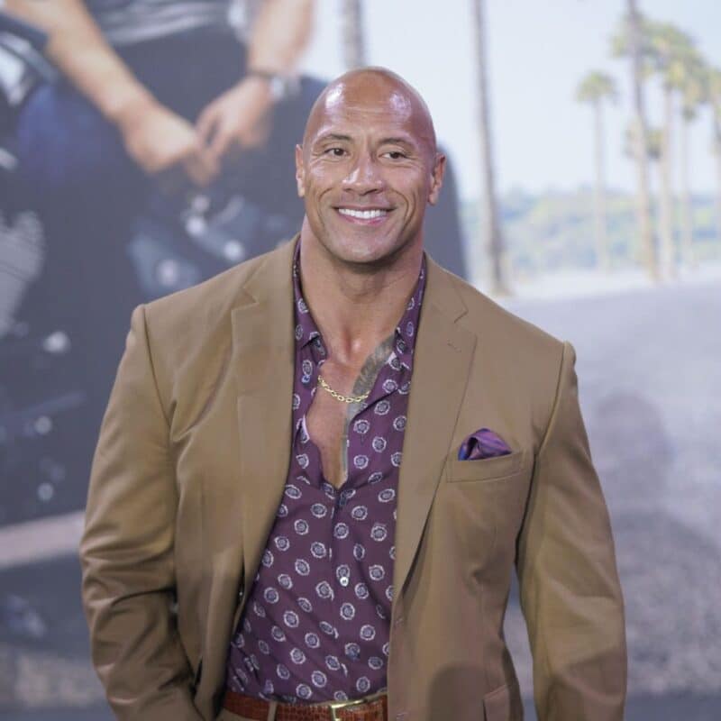 Dwayne Johnson wearing a tan blazer over a patterned shirt