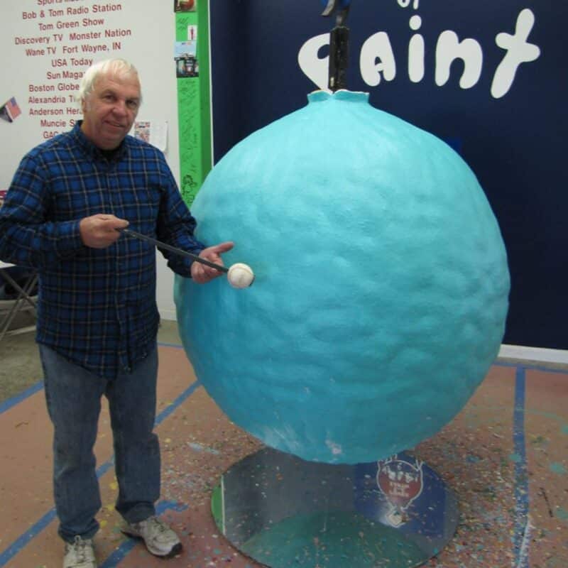 A man standing next to the large ball of paint