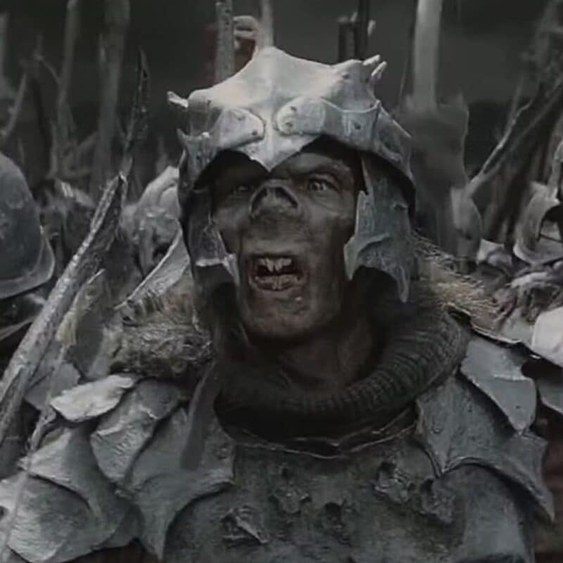 An Orc from The Lord of the Rings wearing detailed, weathered armor and a helmet with jagged edges
