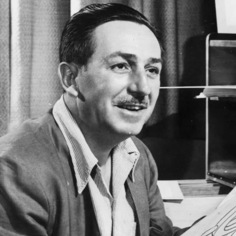 Walt Disney smiling in a black-and-white photo