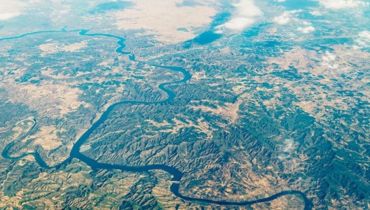 Aerial view of a landscape showing winding rivers and mountainous terrain, representing technology advancements contributing to Google Earth