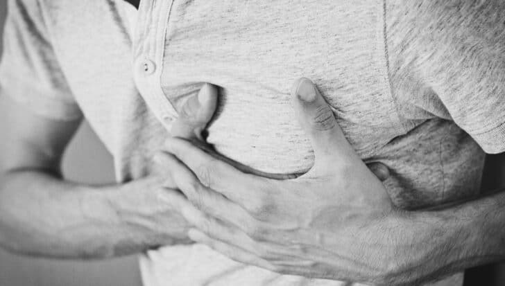 A person clutching their chest, possibly indicative of a heart attack, relating to the CIA heart attack gun